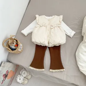 Flat lay of toddler girl three-piece set with quilted bow vest and lace flared pants