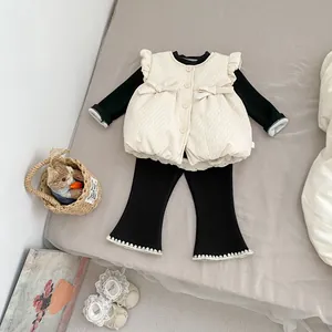 Detail of baby girl quilted vest with frill sleeves, bow ties and lace trim leggings