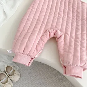 Detail of pink quilted newborn romper with ribbed cuffs and soft fabric texture