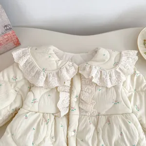 Detailansicht des geblümten Baby-Bodysuits mit Spitzenbesatz und Knöpfen für Kinder