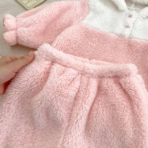 Close-up of soft coral fleece texture and button detail on pink baby winter pajama set