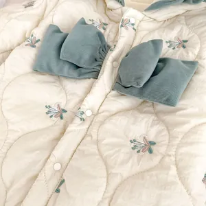 Quilted floral baby romper with elegant blue bow and delicate flower embroidery