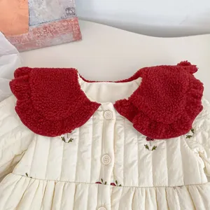 Detail of child's padded jacket with mushroom embroidery and a red plush collar
