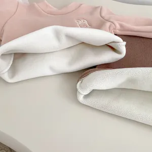 Close-up of thick white fleece lining and cute embroidery on warm winter kids' sweatshirts