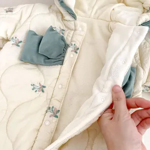 Detail of floral embroidery on a quilted baby romper with warm fleece lining