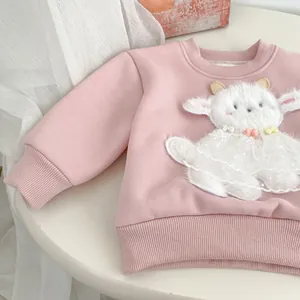 Détail du sweat rose pour enfant avec agneau en peluche 3D, jupe en dentelle et perles