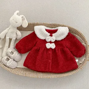 Détail du manteau d'hiver rouge bébé avec col en fausse fourrure et nœuds blancs
