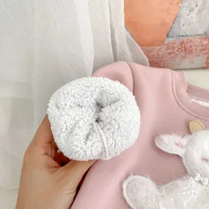 Détail de la doublure polaire douce sur un sweat rose pour enfant avec broderie animal