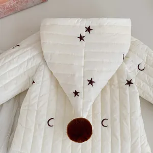 Detailansicht der gesteppten Baby-Kapuzenjacke mit Sternenstickerei und Bommel-Kapuze