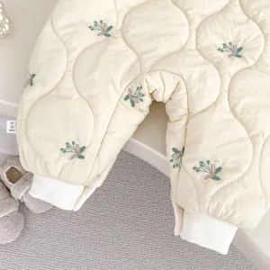 Close-up of baby floral quilted romper with embroidery details and ribbed cuffs