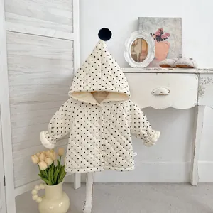 Winter infant hooded quilted jacket in white with black polka dots and plush pom-poms