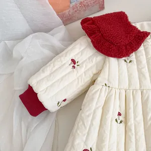 Detail of baby quilted jacket with red sherpa collar and small mushroom embroidery