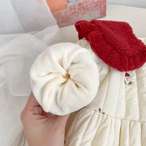 Detail of cream quilted fabric with embroidery and white fleece lining for kids coat