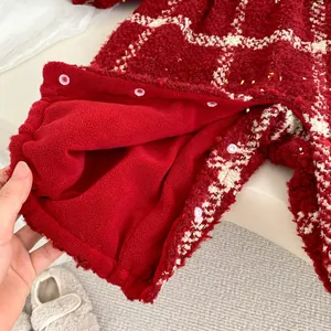 Détail de barboteuse bébé à carreaux rouge et blanc avec paillettes et doublure polaire