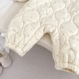 Detailansicht des gesteppten Baby-Bodysuits mit Blumenmuster und elastischen Bündchen