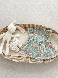 Detailansicht von Baby-Body mit Blumenmuster, Spitzenbesatz und weichen Schuhen