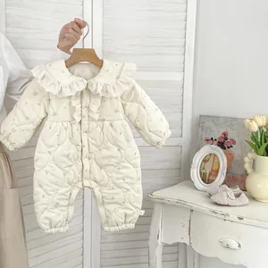 Detail eines geblümten Baby-Stepp-Stramplers mit großem Spitzenkragen und Druckknöpfen
