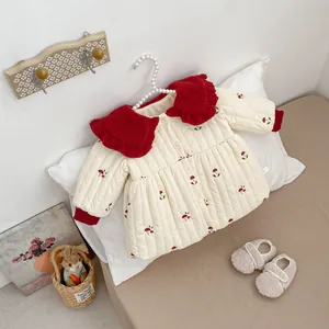 Detail of baby quilted jacket with red plush collar and mushroom embroidery on soft fabric