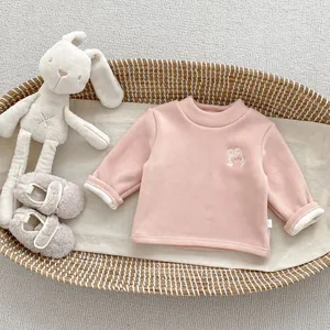 Detailed close-up of pink fleece baby sweatshirt featuring a cute white rabbit embroidery