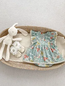 Detail von Baby-Blumenbody mit Spitzenärmeln und Rückennöpfen in einem Weidenkorb