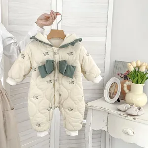 Detail of floral quilted baby romper with green bow and delicate ruffle collar