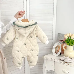 Detail of floral baby winter romper featuring green ruffles and quilted warm fabric