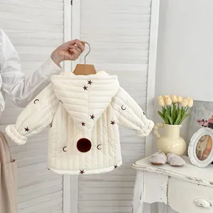 Detail der gesteppten Babyjacke mit Sternenstickerei und süßem Plüsch-Pompon an der Kapuze