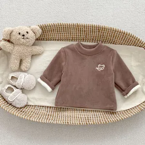 Detail of baby winter fleece top with cute bear embroidery and cozy plush texture