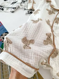 Close-up of baby waffle cotton romper featuring cute bear prints and brown sleeve piping