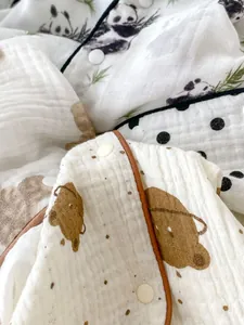 Close-up of soft muslin baby romper with cute panda bear prints and snap fasteners
