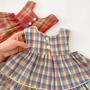 Detailed view of plaid baby girl tank tops with back buttons and piping details