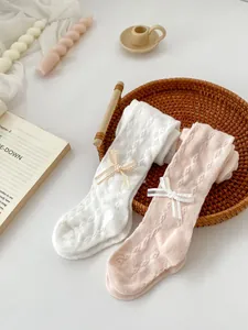 Detail view of baby girls knit tights with openwork texture and cute ribbon bows