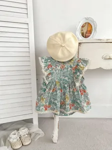 Detailaufnahme des Baby-Blumen-Stramplers mit Spitzenkanten, Baskenmütze und Schuhen