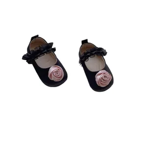 Scarpe neonata nere con rosa di seta rosa e cinturino in rete su sfondo bianco