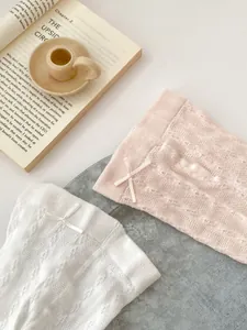Breathable pointelle knit baby tights in white and pink with delicate satin bows