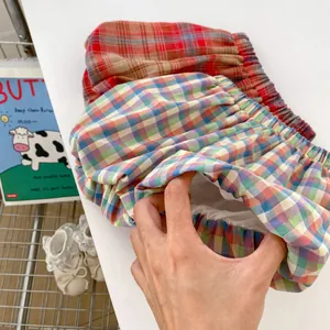 Detail of baby girl plaid shorts with elastic waist and soft white cotton lining