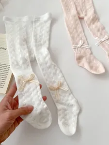 Detail of hollow knit mesh pattern and cute bow ornament on toddler girls' tights
