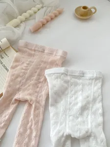 Close-up of baby mesh tights featuring fine hollow jacquard knitting and bow detail