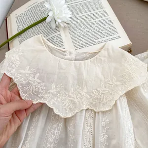 Detailed view of white floral embroidery on a vintage cotton lace collar dress