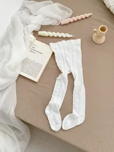 Detailed knit pattern on white toddler tights with a cute side satin bow decoration