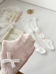Macro detail of breathable mesh fabric and bow ornament on toddler summer leggings