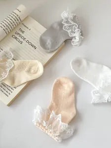 Detail of four color baby cotton socks with elegant white lace trim and breathable mesh fabric