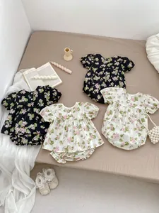 Flat lay detail of floral baby romper set with puff sleeves and elastic bloomers