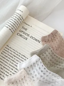 Detailed close-up of breathable mesh pattern on summer cotton socks over a book