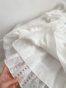 Detailed view of white eyelet lace fabric with floral embroidery and soft lining