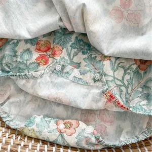 Baby Mädchen Body mit Blumenmuster und Flügelärmeln auf einem hellen Weidenkorb-Hintergrund