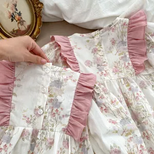 Dettaglio vestito floreale da bambina con volant rosa e chiusura posteriore con bottoni