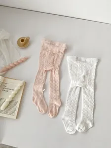 Close-up of baby girl hollow knit leggings in pink and white with delicate lace patterns