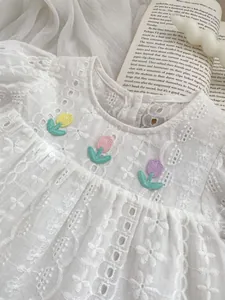 Close-up of floral embroidery and delicate Broderie Anglaise lace on girls cotton dress