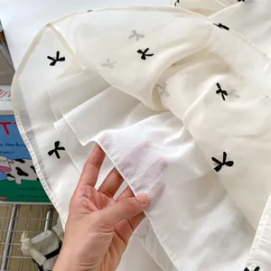 Meisjes prinsessenjurk met pofmouwen en zwarte geborduurde strikjes op witte stof